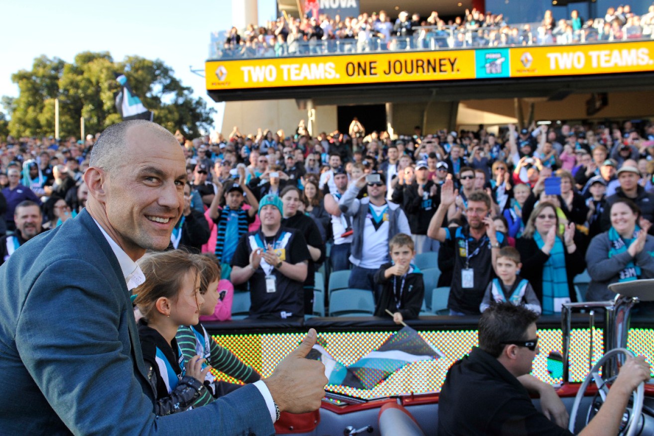 One club, two potential directions: former captain Warren Tredrea, pictured on a motorcade before an Adelaide Oval game in 2014, wants to shake up his club's board. Photo: AAP/David Mariuz