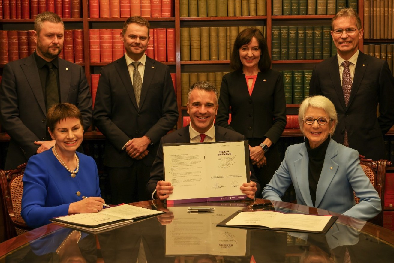 Premier Peter Malinauskas signing the heads of agreement for the merger of the University of Adelaide and UniSA on July 2, 2023. Photo: Tony Lewis/InDaily