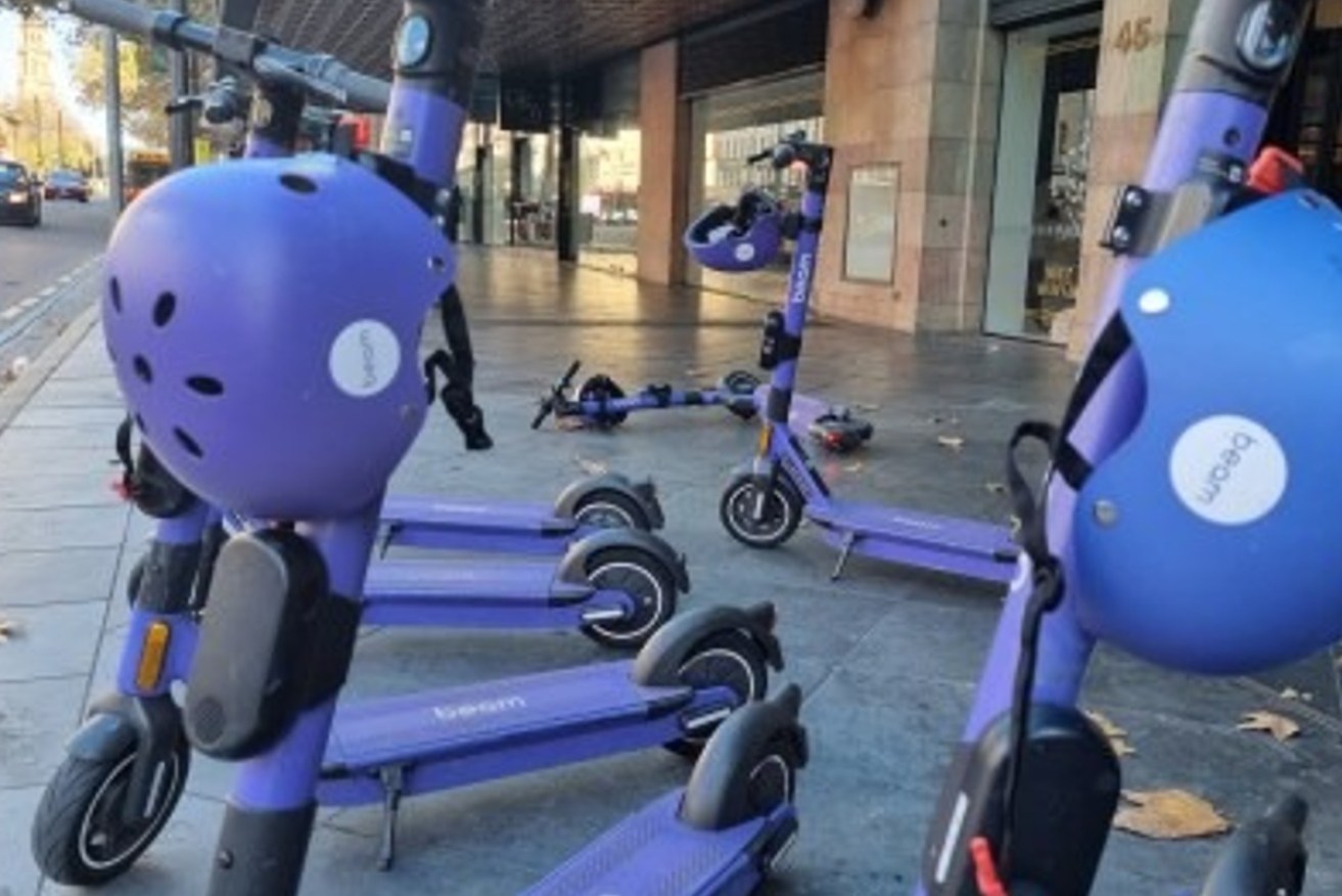 Parked and fallen e-scooters on a city footpath. Photo: Thomas Kelsall/InDaily