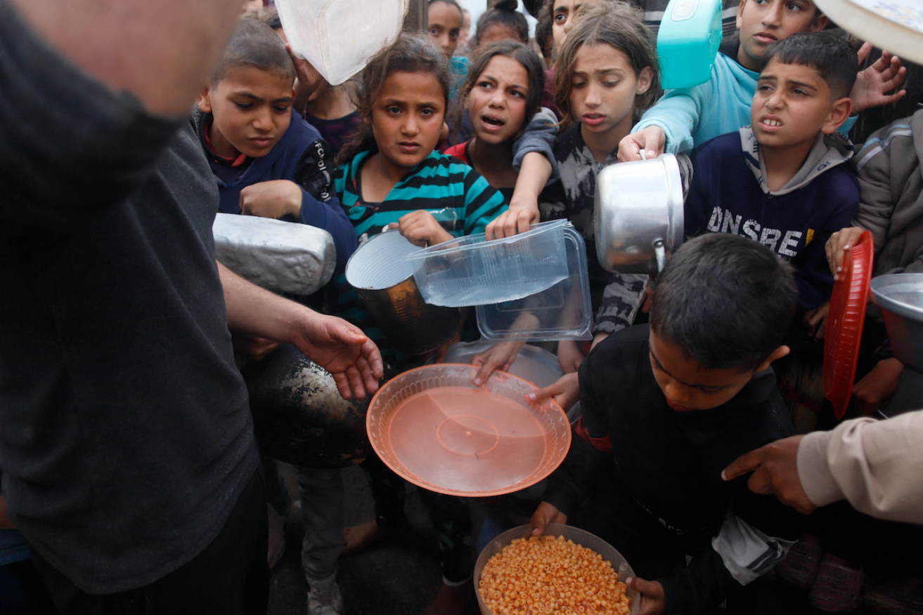 Children wait for food in the southern Gaza city of Rafah. Photo: Habboub Ramez/ABACA/PA/Alamy